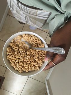 a person holding a bowl of cereal with a measuring tape on the side of it