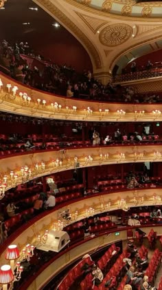 an auditorium filled with people and red seats