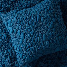 two blue pillows stacked on top of each other