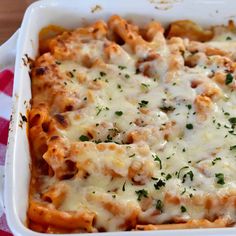 baked pasta casserole in a white dish on a red and white checkered tablecloth