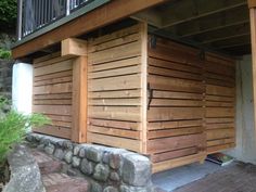 a wooden building with a stone wall next to it