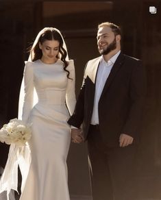 a bride and groom are holding hands