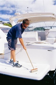 a man with a mop on top of a boat