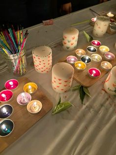 many candles are lit on a table with other items