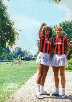 two women standing next to each other on a dirt road