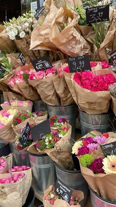 many different types of flowers are in buckets