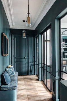 an empty hallway with blue walls and wooden floors