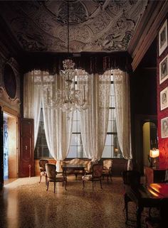 a living room with chandelier, chairs and pictures on the wall in it