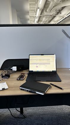 a laptop computer sitting on top of a wooden desk