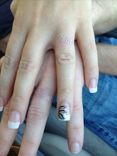 two hands with white and black nail designs on them, one is holding the other's hand