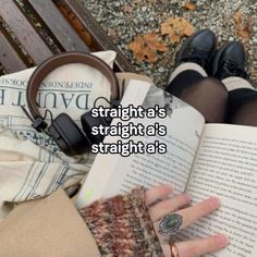 someone is sitting on a bench reading a book and holding their hands in front of them