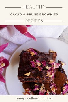 some brownies on a white plate with pink flowers in the background and text overlay that reads healthy cacao & prune brownies recipes