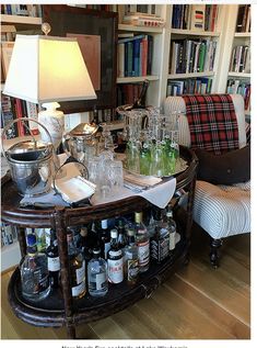 a living room filled with lots of bottles and glasses on top of a wooden table