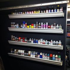 the shelves are filled with many different types of paint