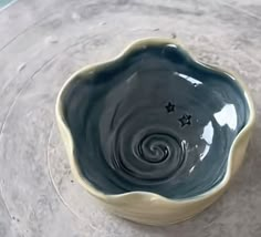 a bowl that is sitting on top of a table with water swirling around the bottom