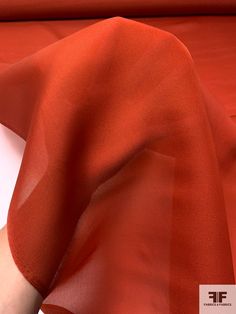 an orange sheet is laying on top of a white piece of paper that has been folded over it