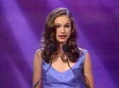 a woman in a blue dress standing at a podium