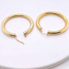 These stunning polished 14k yellow gold hoops provide a look that is both trendy and classic. While they were once worn by kings and queens to signify power and social status, hoop earrings are now considered a statement of unity and strength. Hoop earrings stand out, just like the strong people who sport them. These earrings are a great staple to add to your collection, and can be worn with both casual and formal wear. These hoop earrings would make the perfect gift for your loved one of yourse Classic Gold Hoop Huggie Earrings, Classic Gold Huggie Hoop Earrings, Timeless Round Hoop Earrings For Everyday Luxury, Timeless Everyday Luxury Hoop Earrings, Everyday Luxury Timeless Hoop Earrings, Everyday Luxury Timeless Round Hoop Earrings, Classic Gold-tone Round Huggie Earrings, Gold Small Hoop Classic Rings, Small Hoop Gold Classic Rings