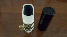 a black and white object sitting on top of a wooden table next to a lighter