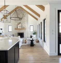 a living room filled with furniture and a fire place in the middle of a kitchen