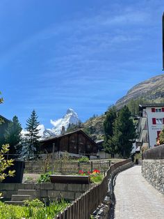 a stone path leading to a building with a mountain in the background