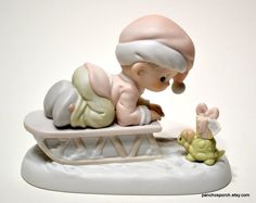 a figurine of a baby laying on top of a sled