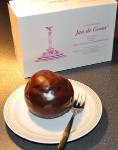 a chocolate dessert sitting on top of a white plate next to a fork and knife