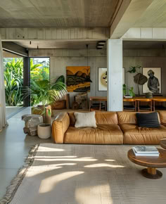 a living room filled with lots of furniture and plants on top of the floor next to windows