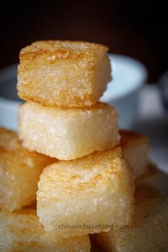 some sugar cubes stacked on top of each other in front of a white bowl