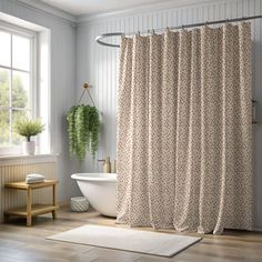 a white bath tub sitting next to a shower curtain in a bathroom under a window