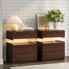 two nightstands side by side in front of a white brick wall with flowers on top