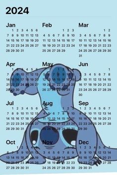 a blue dog sitting on top of a table next to a calendar with the year in it