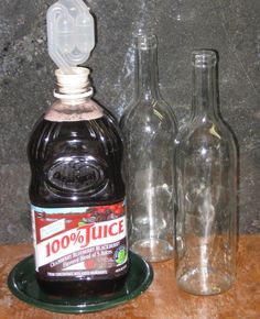 two empty glass bottles sitting next to each other on a wooden table with an empty bottle in the middle