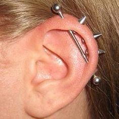 a woman's ear has three piercings on it