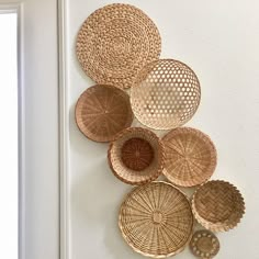 several woven baskets are hanging on the wall