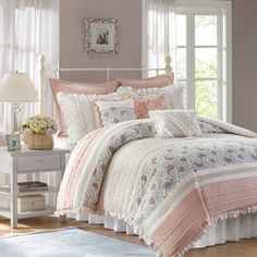 a bed with pink and white comforters in a bedroom