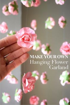 someone is holding pink flowers in their hand with the words make your own hanging flower garland