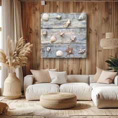 a living room filled with white furniture and lots of sea shells on the wooden wall