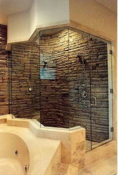 a bathroom with stone walls and a walk in shower