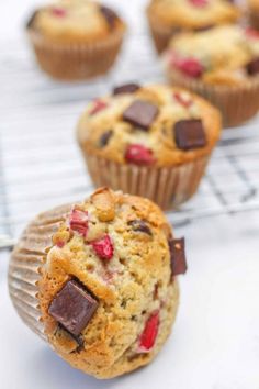 several muffins with chocolate chips and strawberries in them on a cooling rack