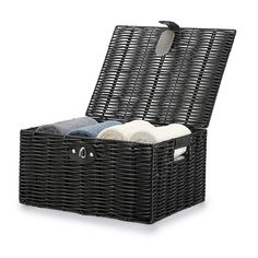 a black wicker box with two towels in it