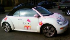 a hello kitty car is parked on the street