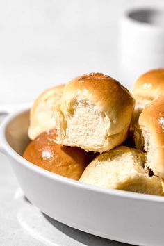 a bowl filled with rolls sitting on top of a table