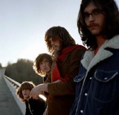 three young men standing on the side of a road