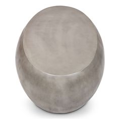 a round concrete stool sitting on top of a white floor