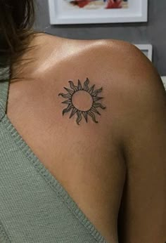 a woman with a small sun tattoo on her shoulder