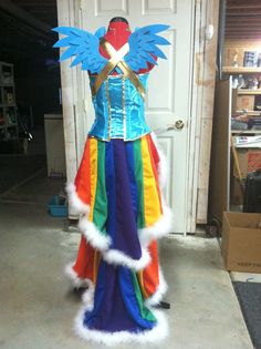 a mannequin dressed in colorful clothing stands next to a white door and looks at the camera