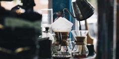 an espresso machine is pouring coffee into a glass cup on a counter top