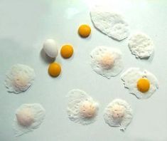 eggs are arranged in the shape of four on a white surface with one egg missing