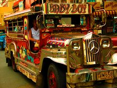 the man is sitting in the driver's seat of an old style bus on the street